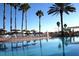 Inviting swimming pool area with lounge chairs, umbrellas, and swaying palm trees under a sunny sky at 9346 Southern Belle Dr, Weeki Wachee, FL 34613