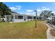 View of the lawn, screened-in lanai and boat dock from the side yard at 100 18Th Nw St, Ruskin, FL 33570