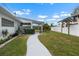 Sprawling backyard with a well manicured lawn, white fence, and tropical landscaping at 100 18Th Nw St, Ruskin, FL 33570