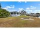 Waterfront backyard featuring a screened porch, fire pit, and private boat dock at 100 18Th Nw St, Ruskin, FL 33570