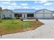 Charming home exterior with a well-manicured lawn, inviting entrance, and a convenient two-car garage at 100 18Th Nw St, Ruskin, FL 33570