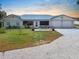 Charming home exterior with well-manicured lawn, double garage, and metal roof at 100 18Th Nw St, Ruskin, FL 33570