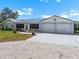Inviting home exterior with lush landscaping, a manicured lawn, and a spacious driveway leading to a two-car garage at 100 18Th Nw St, Ruskin, FL 33570