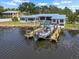 Waterfront home featuring a boat lift, dock, and peaceful water views at 100 18Th Nw St, Ruskin, FL 33570