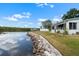 Waterfront lawn with rock seawall and boat dock on a clear day at 100 18Th Nw St, Ruskin, FL 33570