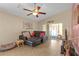 Cozy living room with a ceiling fan, tile flooring, and sliding glass doors to the screened patio at 1022 Chandler Snowden Ct, Ruskin, FL 33570