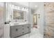 Modern bathroom featuring double sinks, a gray vanity, and a luxurious marble tiled shower at 1211 E Comanche Ave, Tampa, FL 33604
