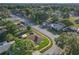 Aerial view showcases a home nestled in a tranquil neighborhood with lush greenery and tree-lined streets at 12817 Lake Tree Ln, Hudson, FL 34669