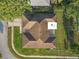 Aerial view of a home with a well-maintained lawn and distinctive roof design in a residential neighborhood at 12817 Lake Tree Ln, Hudson, FL 34669
