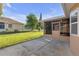 Backyard featuring a concrete patio, screen door and luscious grass at 12817 Lake Tree Ln, Hudson, FL 34669