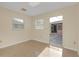 Cozy bedroom with neutral walls, tiled floors, and natural light from two windows at 12817 Lake Tree Ln, Hudson, FL 34669