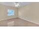 Neutral bedroom features ceiling fan, light, and one window with tan walls at 12817 Lake Tree Ln, Hudson, FL 34669