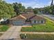 Single-story home with a large driveway, well-manicured lawn, and a traditional mailbox at 12817 Lake Tree Ln, Hudson, FL 34669