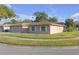 Charming single-story home with a lush green lawn, mature trees, and a well-maintained yard at 12817 Lake Tree Ln, Hudson, FL 34669