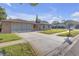 Single-story home with a large driveway, well-manicured lawn, and a traditional mailbox at 12817 Lake Tree Ln, Hudson, FL 34669