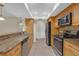 Well-lit kitchen features granite countertops, stainless steel appliances, and wood cabinetry at 12817 Lake Tree Ln, Hudson, FL 34669