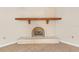 Living room fireplace with white brick and wooden beam at 12817 Lake Tree Ln, Hudson, FL 34669