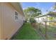Narrow side yard featuring lush lawn and privacy from a chain-link fence at 12817 Lake Tree Ln, Hudson, FL 34669