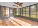 Inviting sunroom with terra cotta tiled floor, a ceiling fan, and views of the backyard at 12817 Lake Tree Ln, Hudson, FL 34669