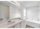 Bathroom featuring double sinks, white cabinets, and a bathtub at 1408 Birchstone Ave, Brandon, FL 33511