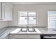 Bright kitchen featuring a stainless sink and marble countertops with a window view at 1408 Birchstone Ave, Brandon, FL 33511