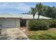 Inviting home featuring mature palm trees, an attached garage, and a well-maintained lawn at 1445 72Nd Ne Ave, St Petersburg, FL 33702