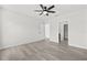 Bedroom with wood look floors, ceiling fan, and adjoining bathroom at 14498 Whitewater Way, Brooksville, FL 34604