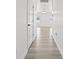 Bright hallway with wood-look floors, leading to a view of windows at the end at 14498 Whitewater Way, Brooksville, FL 34604