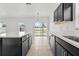 Modern kitchen with black cabinetry, white countertops, stainless sink, and view to backyard at 14498 Whitewater Way, Brooksville, FL 34604