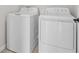 Bright laundry room featuring a modern, white washer and dryer set at 14498 Whitewater Way, Brooksville, FL 34604