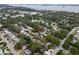 Aerial view showcasing the property's location within a neighborhood near a lake, surrounded by mature trees at 1526 San Mateo Dr, Dunedin, FL 34698