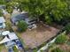 Aerial view of a house with a spacious backyard and patio area, surrounded by mature trees and lush landscaping at 1526 San Mateo Dr, Dunedin, FL 34698
