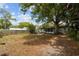 Expansive backyard featuring lush trees and a cozy patio area, perfect for outdoor relaxation and entertainment at 1526 San Mateo Dr, Dunedin, FL 34698