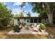 Inviting backyard patio featuring comfortable seating, lush greenery, and a charming turquoise door at 1526 San Mateo Dr, Dunedin, FL 34698