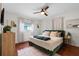 Cozy bedroom with hardwood floors, featuring a comfortable green bed and natural lighting at 1526 San Mateo Dr, Dunedin, FL 34698