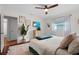 Bright bedroom featuring hardwood floors, modern decor, television, and a ceiling fan at 1526 San Mateo Dr, Dunedin, FL 34698