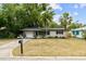 Charming single-story home with mature trees and a well-maintained lawn at 1526 San Mateo Dr, Dunedin, FL 34698
