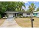 Charming single-story home with mature trees and a well-maintained lawn at 1526 San Mateo Dr, Dunedin, FL 34698