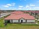 Aerial view of modern homes with red tiled roofs in a vibrant community at 17222 Holly Well Ave, Wimauma, FL 33598