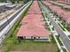 Aerial view of a community of homes with red roofs, adjacent to a busy street at 17222 Holly Well Ave, Wimauma, FL 33598