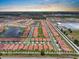Stunning aerial view showcases a Primary-planned community, highlighting rows of homes with terracotta roofs and scenic ponds at 17222 Holly Well Ave, Wimauma, FL 33598