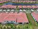 Aerial view of a community of homes with red roofs surrounding a pond at 17222 Holly Well Ave, Wimauma, FL 33598