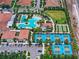 Aerial view showcases the pool, tennis courts, clubhouse, parking and green space of a vibrant community center at 17222 Holly Well Ave, Wimauma, FL 33598