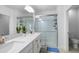 Stylish bathroom featuring a double vanity, quartz countertops, and a tiled shower at 17222 Holly Well Ave, Wimauma, FL 33598