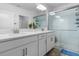 Modern bathroom with double sinks, white cabinets, and a glass-enclosed shower at 17222 Holly Well Ave, Wimauma, FL 33598