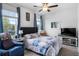 Comfortable bedroom featuring a queen bed, ceiling fan, and blue accents at 17222 Holly Well Ave, Wimauma, FL 33598