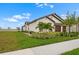 Attractive single-story home with a well-manicured lawn and lush landscaping at 17222 Holly Well Ave, Wimauma, FL 33598