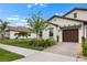 Beautiful house with brick paver driveway, tile roof and lush, green landscaping in a serene setting at 17222 Holly Well Ave, Wimauma, FL 33598