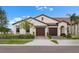 Inviting home featuring a clay tile roof, two-car garage, and well-maintained landscaping at 17222 Holly Well Ave, Wimauma, FL 33598