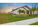 Lovely home features lush green grass, mature landscaping, a two-car garage, and a private yard at 17222 Holly Well Ave, Wimauma, FL 33598